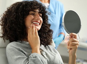 Happy cosmetic dentistry patient looking in mirror