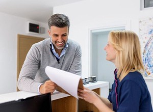 Dental team member assisting patient at front desk
