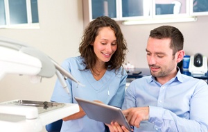 Dentist and male patient discussing tooth replacement options