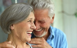 Laughing senior couple enjoying the benefits of All-on-4 dental implants