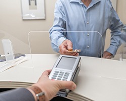 Patient using card to pay for dental treatment