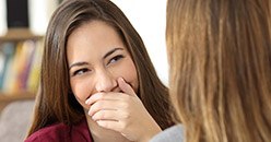 Young woman covering her smile with her hand