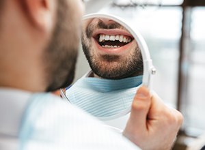 Man looking at smile in mirror