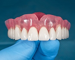 Denture for upper arch balanced on gloved hand