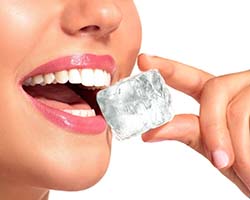 Closeup of patient headed for a dental emergency in Enfield chewing on ice