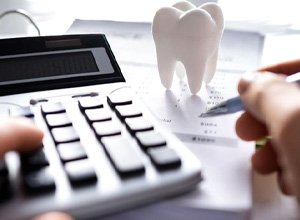 Person using calculator to budget for dental care