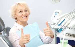 thumbs up from senior dental patient