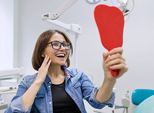 young woman admiring her new dental implants in Enfield