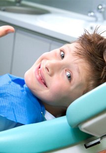 child giving thumbs up while in treatment chair 