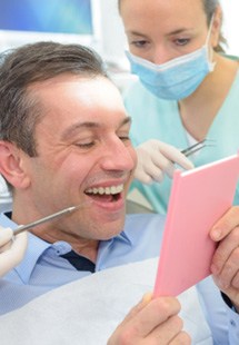 patient smiling while looking in mirror 