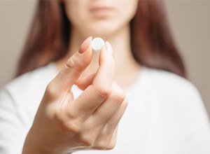Patient holding white pill for oral conscious sedation