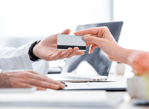 Patient handing over card to pay for dental treatment