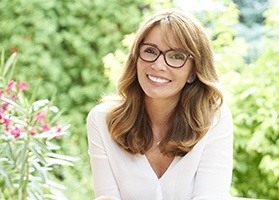 Woman in glasses smiling outdoors