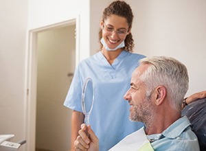 Happy dental patient admiring results of his cosmetic treatment