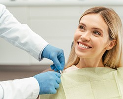 Dental patient smiling up at her dentist