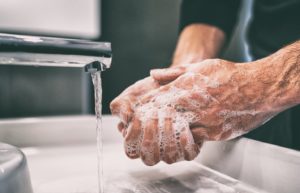 Man washing hands before handling Invisalign in Enfield