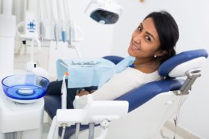 Patient in treatment chair, smiling over her shoulder