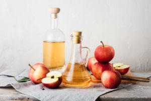 Apple cider vinegar next to apples