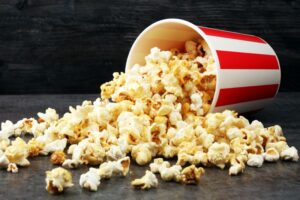 Bucket of popcorn spilled on dark surface